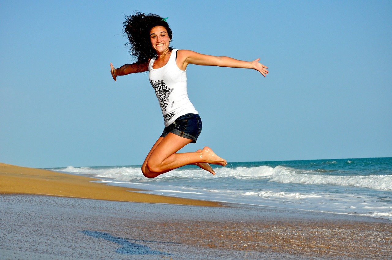 Mulher feliz na praia mesmo longe do ex namorado